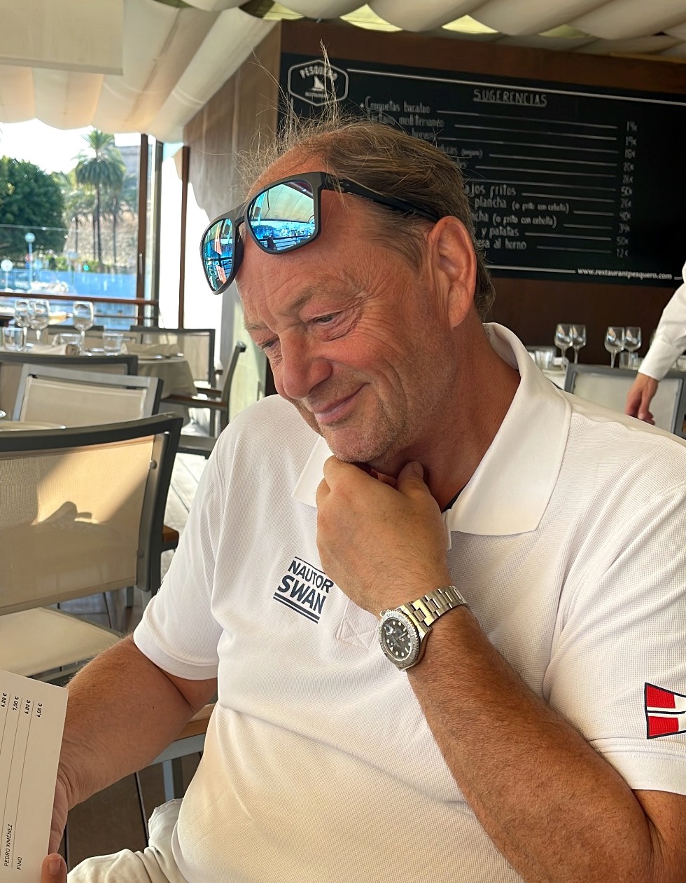 Filip Beyens wearing his Nautor Swan polo shirt at a waterfront restaurant